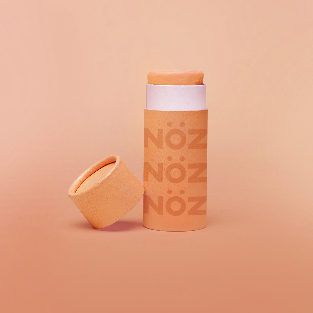 Front view of Nöz Color Variety Sunscreen. Orange with cap off