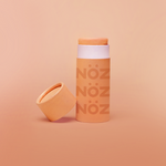 Load image into Gallery viewer, Front view of Nöz Color Variety Sunscreen. Orange with cap off
